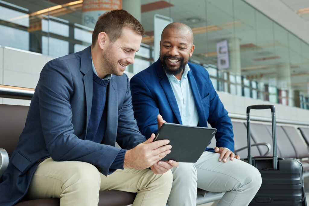airport, business team people and tablet talking of flight schedule, travel news or fintech management. happy investment black man, international partner and digital technology for immigration advice